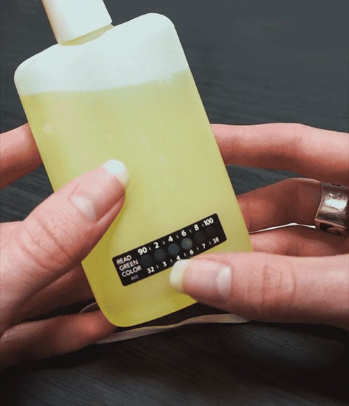 woman holding spectrum labs urine bottle