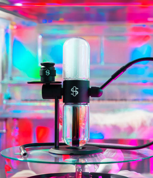 Stundenglass on glass reflective table with colorful lights