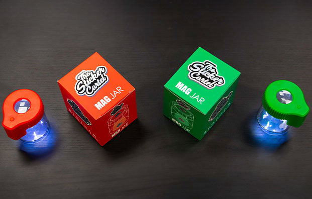 The Sticker Cartel Mag Jar red and green Stash Box on black table