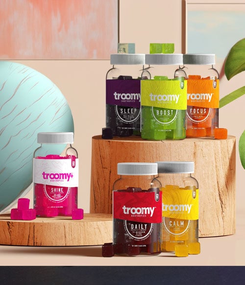 Troomy products on wooden platform with wall art behind