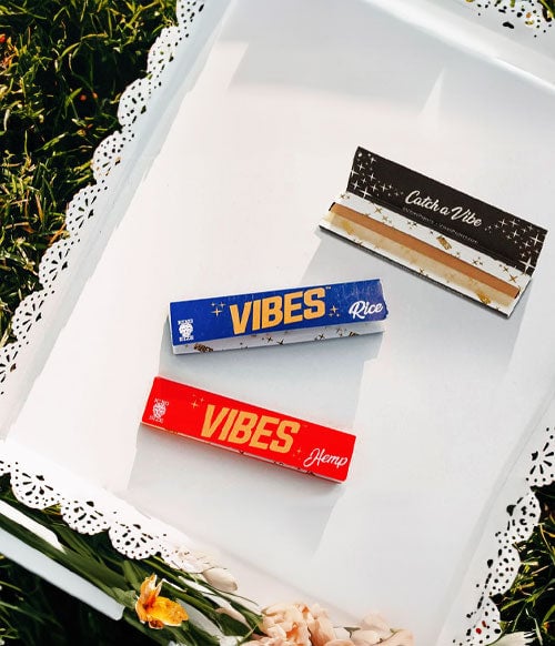 Vibes Papers resting in white basket on top of grass