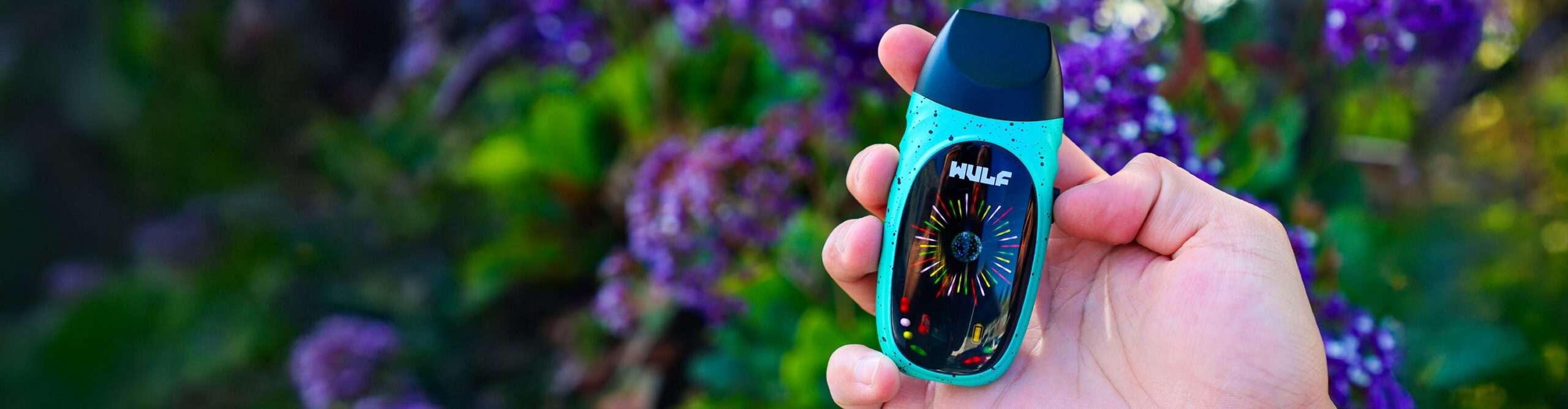 Wulf Faze Dry Herb Vaporizer with purple flowers and green grass in background