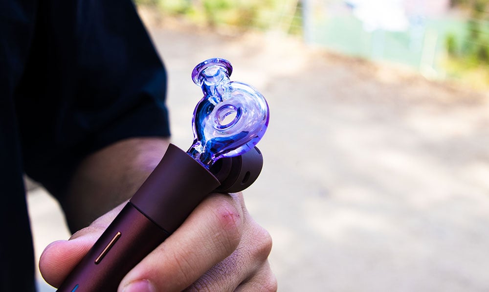 man holding the Puffco Pivot with Wulf Ring Glass Attachement at park