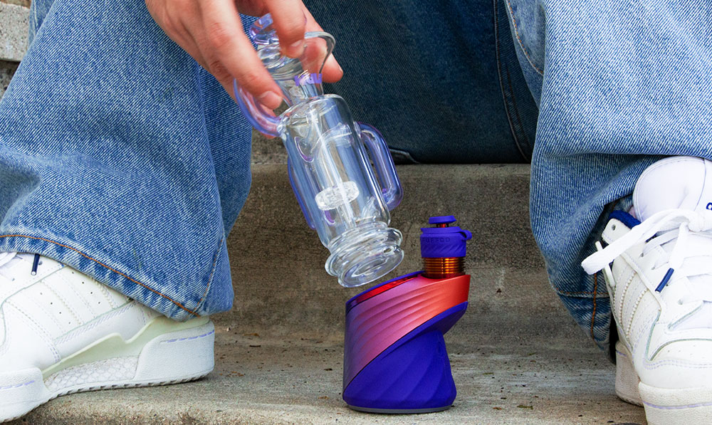 man picking up the Puffco Peak Plasma with Wulf Quake Glass Attachment
