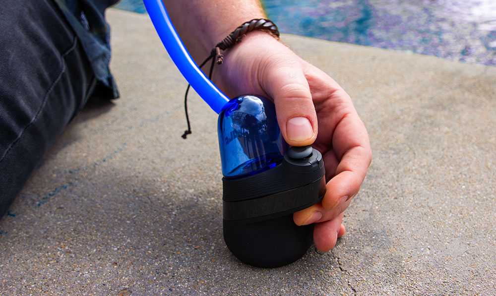 man using the Wulf Link Puffco Peak Glass Attachment with Peak at Park