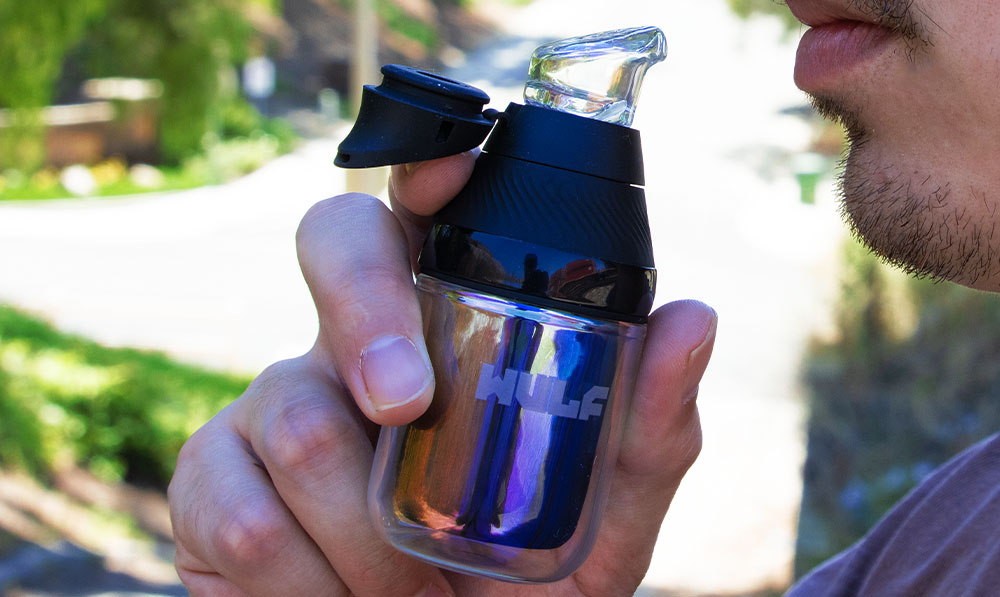 man holding the Puffco Proxy Core with Wulf Nest Glass Attachement outside